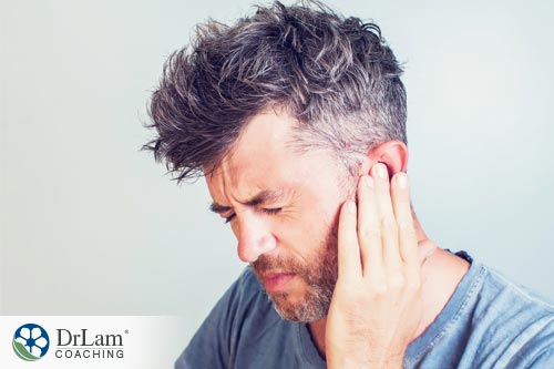 man clutching his ear that is rining because of metabolic inner ear disorder