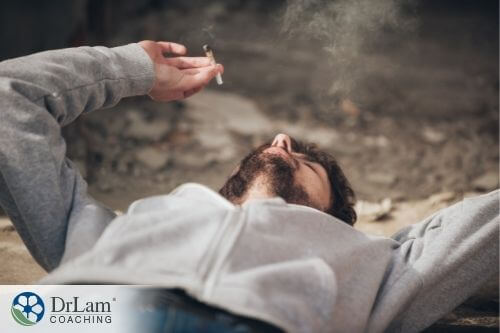 An image of a man lying down on his back while smoking