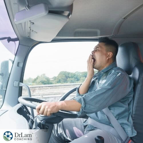 An image of a man yawning while driving