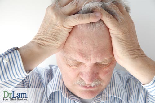 A man grabbing his head looking tired and stressed, suffering from irritability and adrenal fatigue.